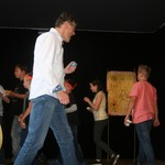 Mit Rhythmus und Gesang tanzen die Schüler und Schülerinnen der Klasse 5 um eine Lagerstelle – Herr Köjer tanzt mit.  (vergrößerte Bildansicht wird geöffnet)