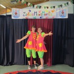 In Clownskostümen werden die Zuschauer von zwei Lehrerinnen empfangen. (vergrößerte Bildansicht wird geöffnet)